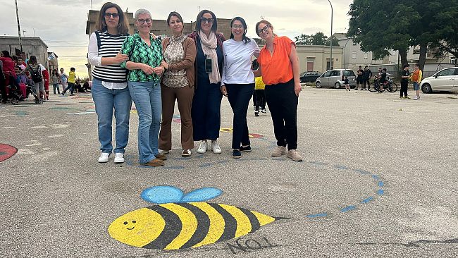 Un quartiere in festa con i graffiti a terra del gruppo NOI odv
