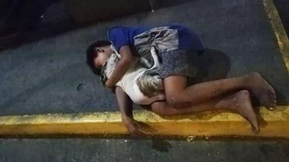 Bimbo senzatetto dorme sul marciapiede abbracciato al cane: la foto simbolo di miseria e amicizia